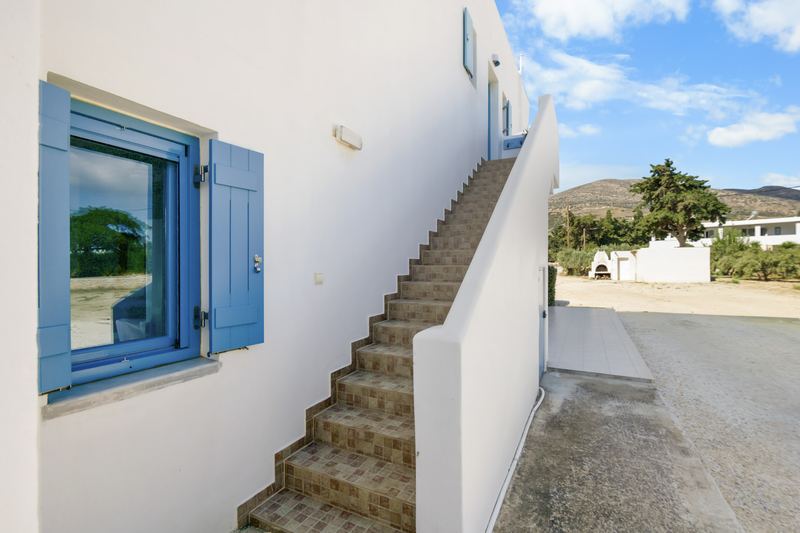 Jasmine apartment, Flora Apartments Paros – whitewashed exterior with blue shutters