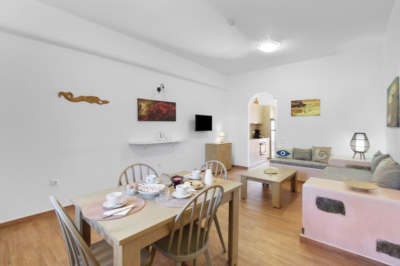 Margarita apartment, Flora Apartments Paros – living room with built-in sofa and dining area