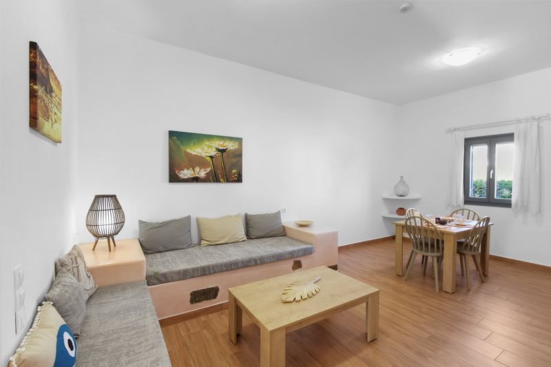 Margarita apartment, Flora Apartments Paros – living room with built-in sofa and dining area