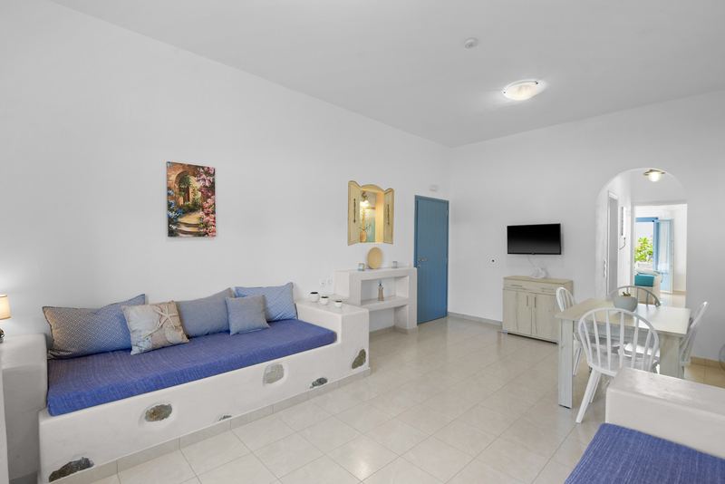 Rose apartment, Flora Apartments Paros – living room with built-in sofas and dining area